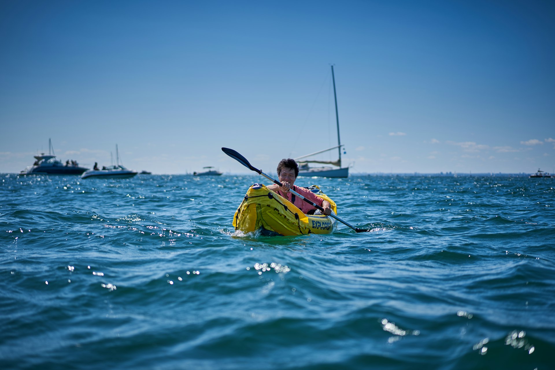 A man in a kayak paddling in the ocean
